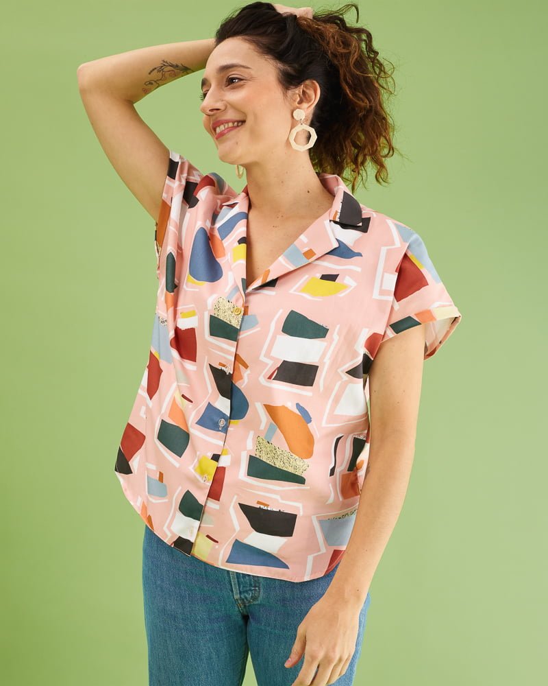 Camisa illán estampado collage en rosa. Corte suelto, cuello amplio y manga corta japonesa. Bajo ligeramente asimétrico. 100% algodón satinado. Hecha en España por peSeta