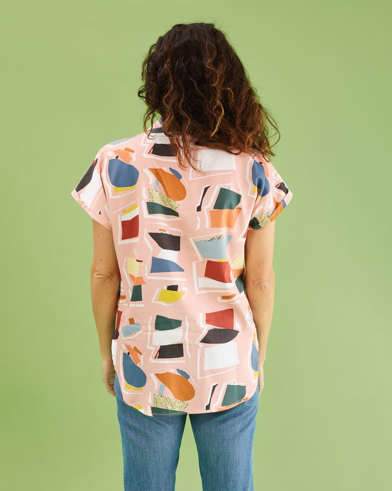 Camisa illán estampado collage en rosa. Corte suelto, cuello amplio y manga corta japonesa. Bajo ligeramente asimétrico. 100% algodón satinado. Hecha en España por peSeta