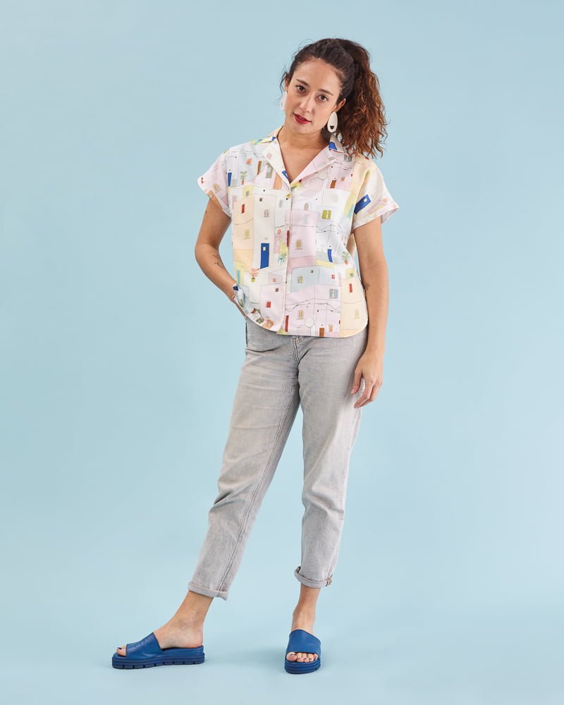 Camisa illán estampado Fachadas con corte suelto, cuello amplio y manga corta japonesa. Bajo ligeramente asimétrico. 100% algodón satinado. Hecha en España