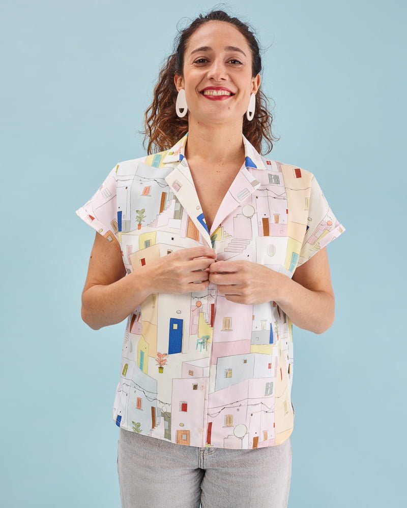 Camisa illán estampado Fachadas con corte suelto, cuello amplio y manga corta japonesa. Bajo ligeramente asimétrico. 100% algodón satinado. Hecha en España
