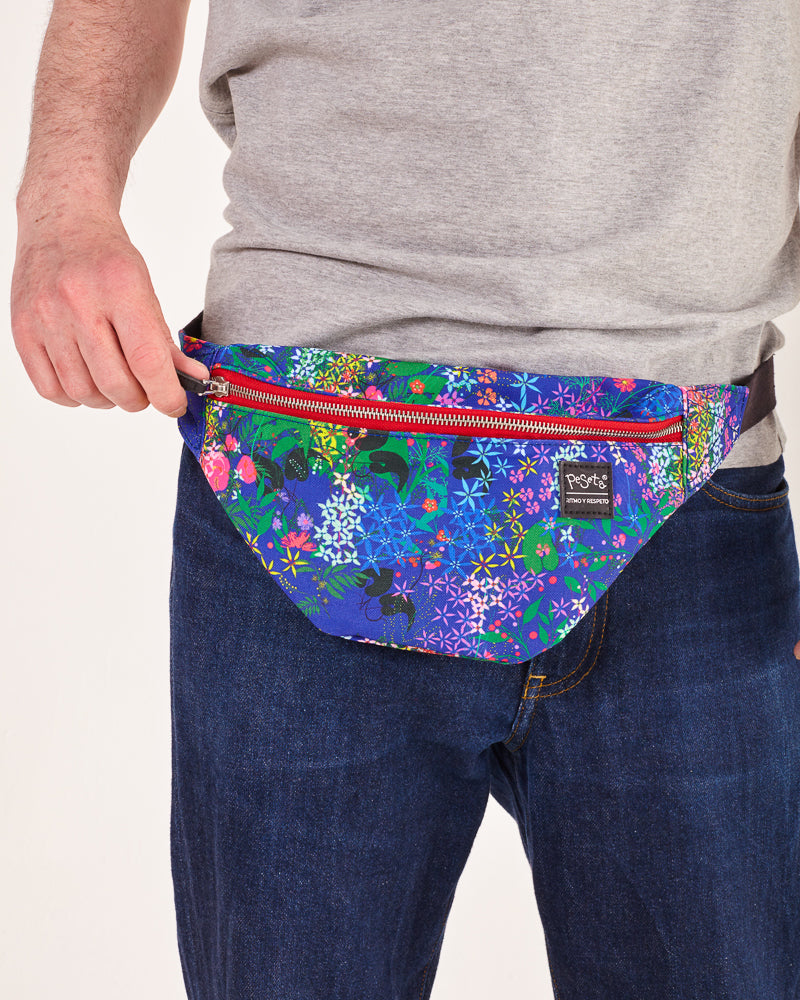 bolso-riñonera nuria flores con cierre delantero, cinta regulable, estampado original de flores sobre un fondo azul, moda lentita, moda española, marca unisex