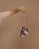 peSeta-PET-cartera-pequena-pieles, cartera multifuncional pequeña pero ultra versatil, estampado de puños em alza con pieles de todos los tonos, con cierre y correa rosa, moda lentita, moda española estampados originales