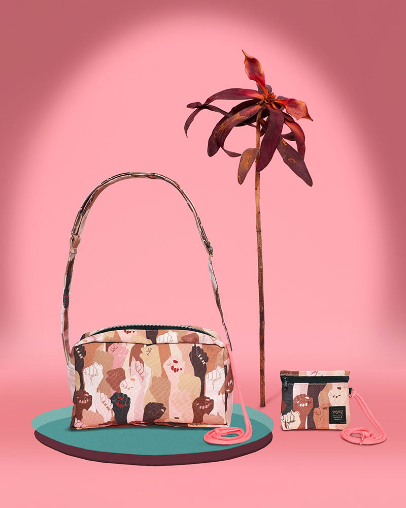 Bolso bandolera con asa regulable y compartimentos interiores. Estampado con un diseño de manos en alza de pieles de todos los tonos, moda lentita, moda española, moda femenina