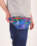 bolso-riñonera nuria flores con cierre delantero, cinta regulable, estampado original de flores sobre un fondo azul, moda lentita, moda española, marca unisex