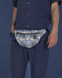 bolso-riñonera TinyHouses  con cierre delantero, cinta regulable, estampado original de casas pequeñas sobre un fondo azul con rayitas , moda lentita, moda española, marca unisex