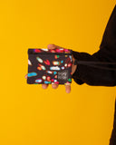 peSeta-PET-cartera-pequena-lux-1, cartera multifuncional pequeña pero ultra versatil, estampado de luces de distintos colores sobre un fondo oscuro, moda lentita, moda española estampados originales