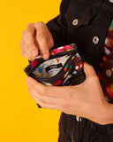 peSeta-PET-cartera-pequena-lux-1, cartera multifuncional pequeña pero ultra versatil, estampado de luces de distintos colores sobre un fondo oscuro, moda lentita, moda española estampados originales