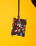 peSeta-PET-cartera-pequena-lux-1, cartera multifuncional pequeña pero ultra versatil, estampado de luces de distintos colores sobre un fondo oscuro, moda lentita, moda española estampados originales