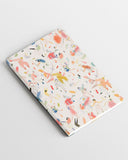 Cuaderno pequeño estampado Bailoteo con hojas en blanco, con estampado original motivo baile, con diferentes personas bailando con tonos rosa, azul y amarillo sobre un fondo blanco, diseños divertidos, moda española, materiales reciclados, accesorios multifuncionales